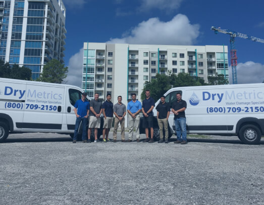 DryMetrics team standing in front of two company vans